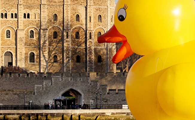 A giant 50 foot rubber duck floats past the Tower of London